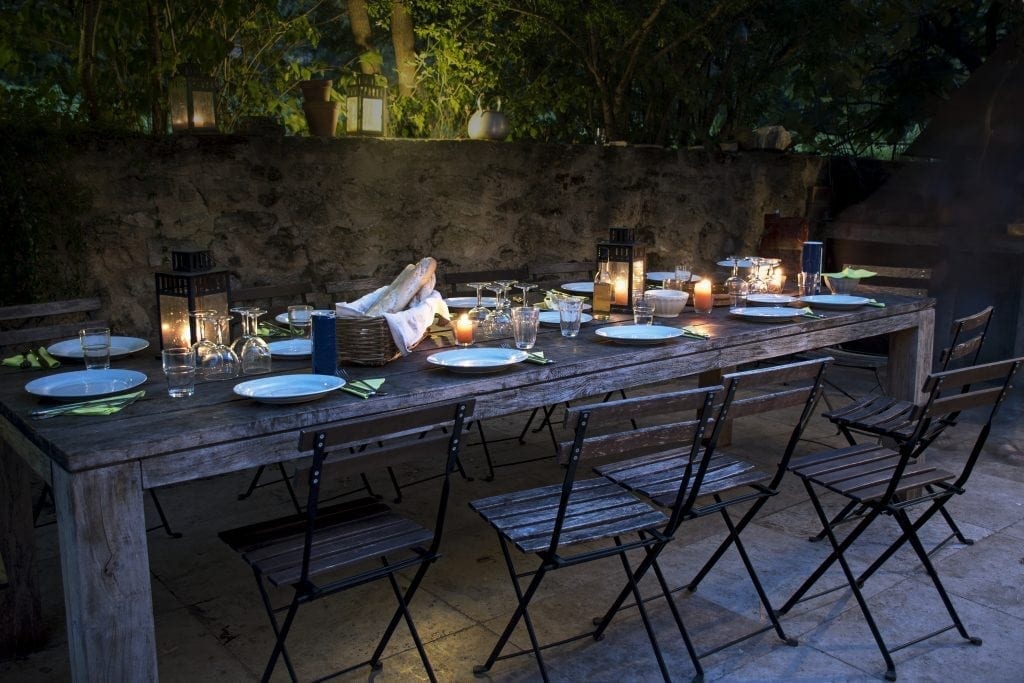 Large Rustic Table Prepared For A Outside Dinner At Night